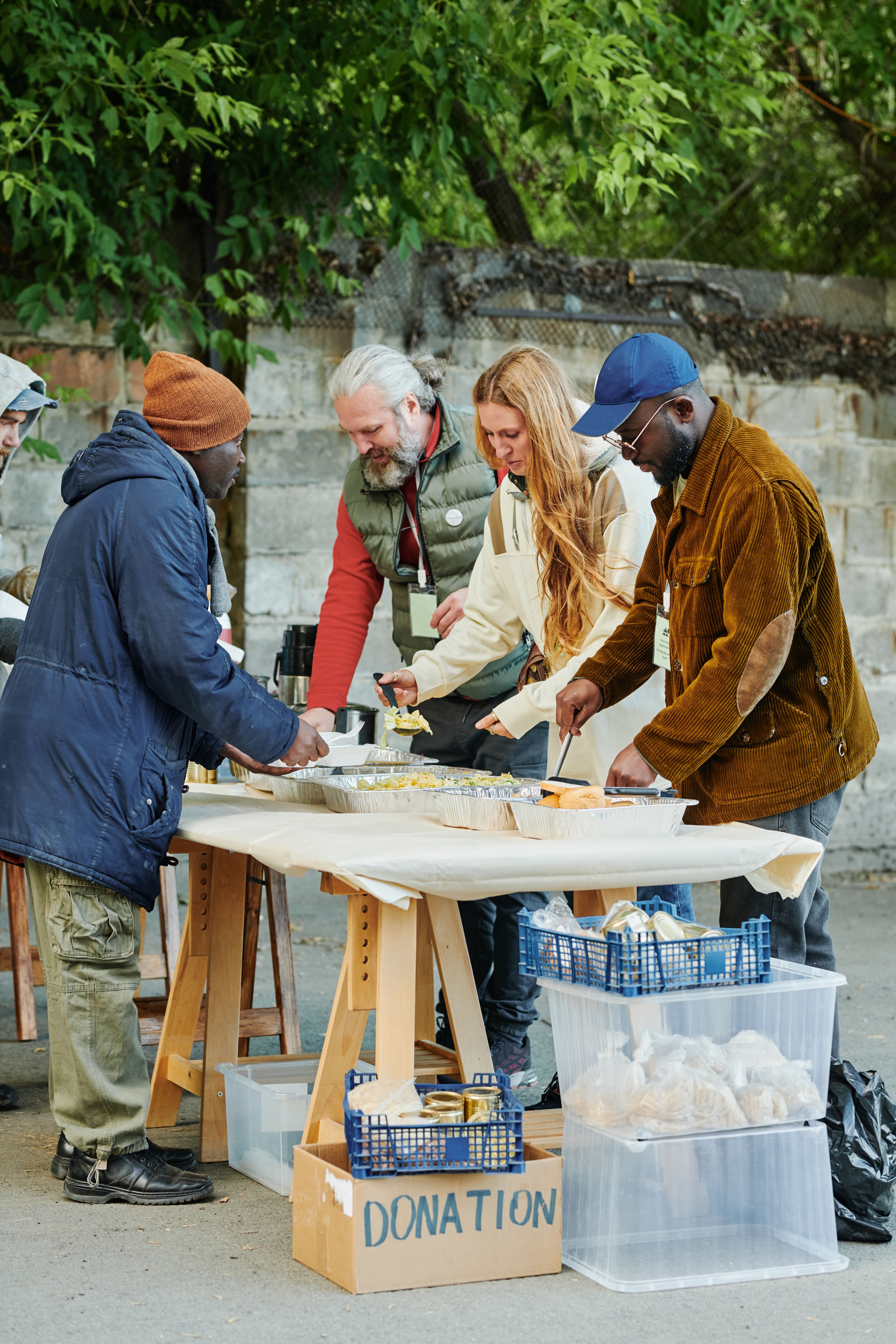 Volunteers feeding homeless people with food